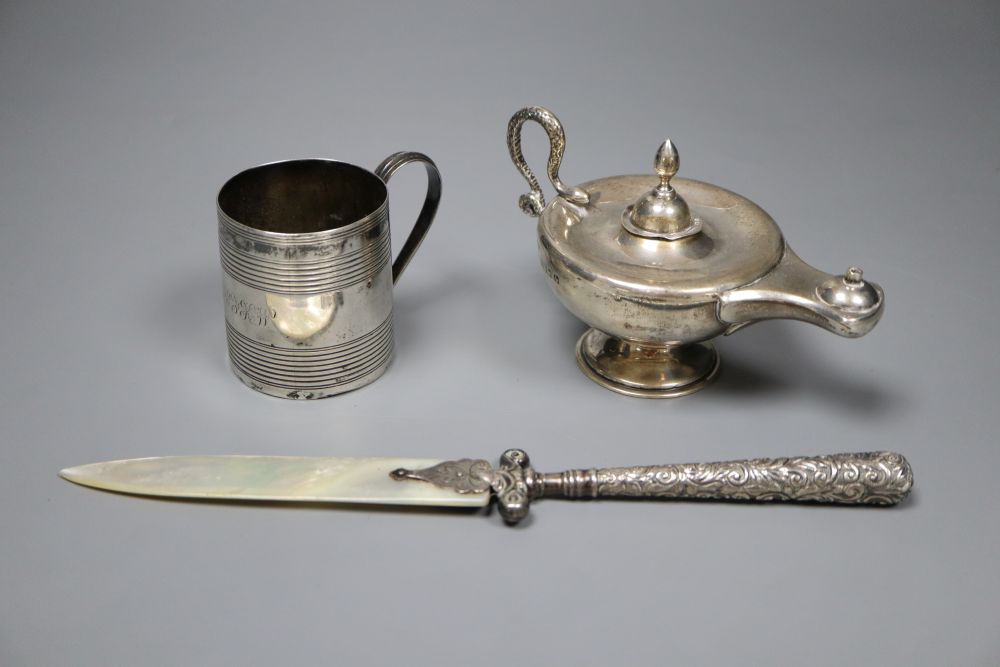 A George III reeded silver small mug, London, 1807, 6.3cm, an Edwardian Aladdins lamp perpetual lighter and a paper knife.